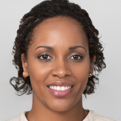 Joyful black young-adult female with medium  brown hair and brown eyes