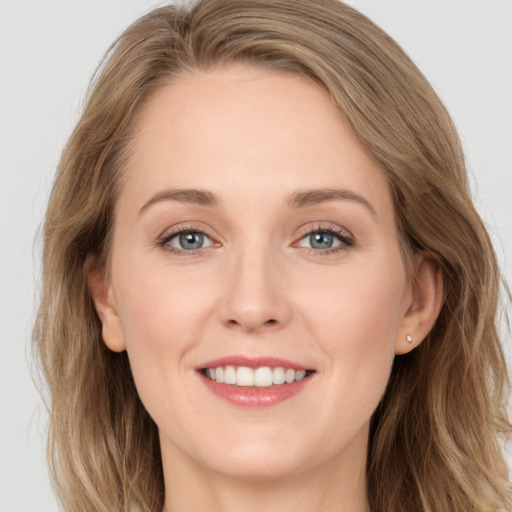 Joyful white young-adult female with long  brown hair and grey eyes