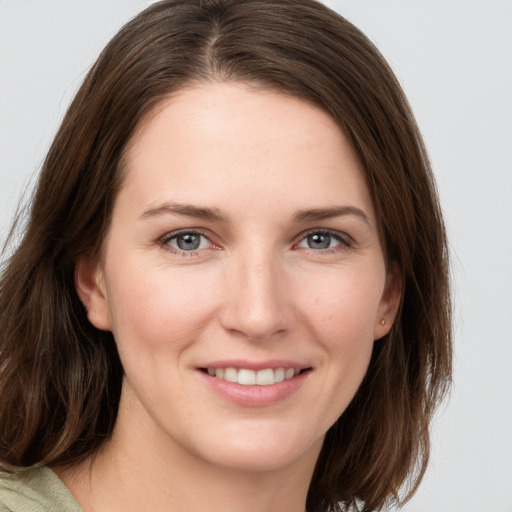 Joyful white young-adult female with medium  brown hair and grey eyes