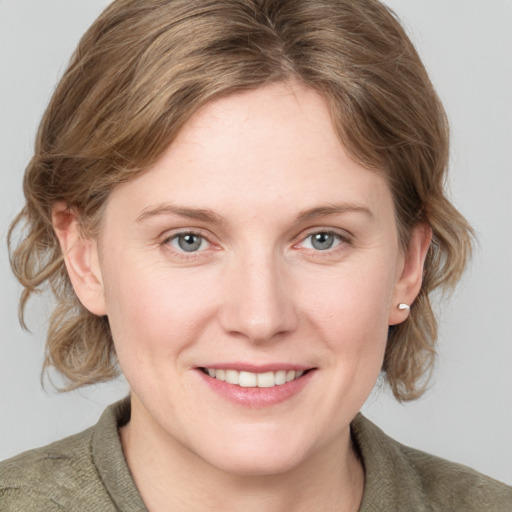 Joyful white young-adult female with medium  brown hair and blue eyes