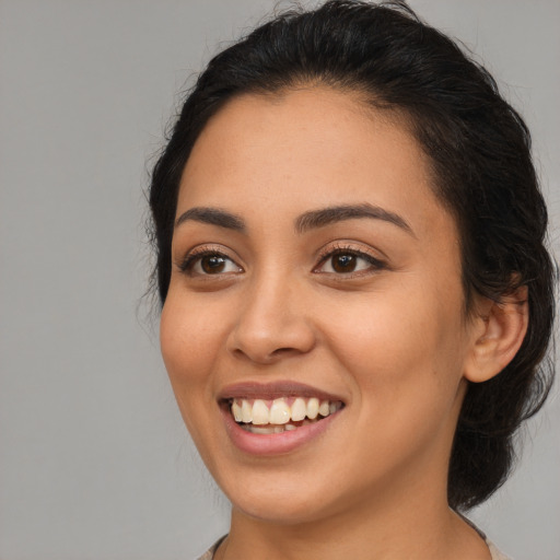 Joyful latino young-adult female with long  black hair and brown eyes