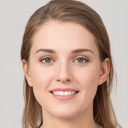 Joyful white young-adult female with long  brown hair and blue eyes