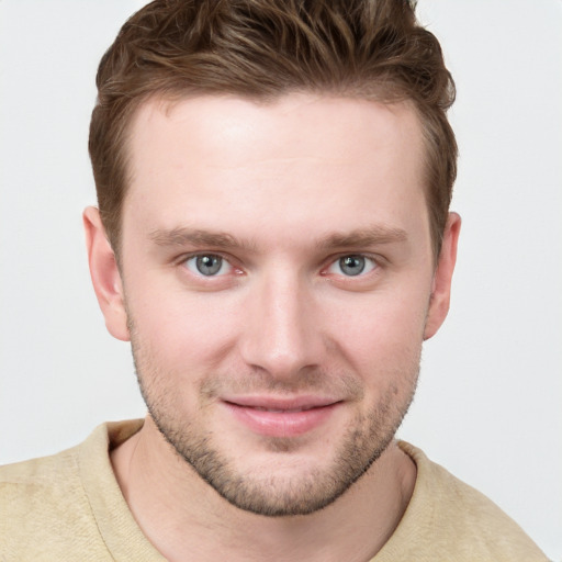 Joyful white young-adult male with short  brown hair and blue eyes