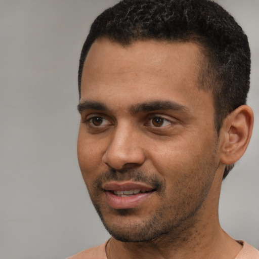 Joyful black young-adult male with short  black hair and brown eyes