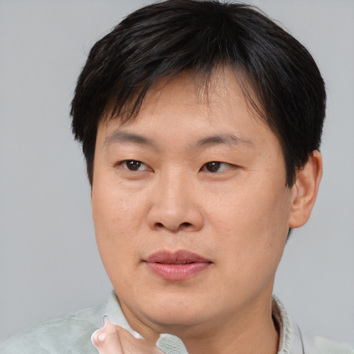 Joyful asian young-adult male with short  brown hair and brown eyes