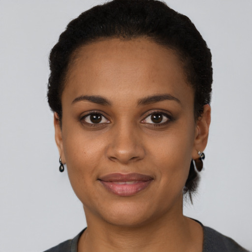 Joyful black young-adult female with short  black hair and brown eyes