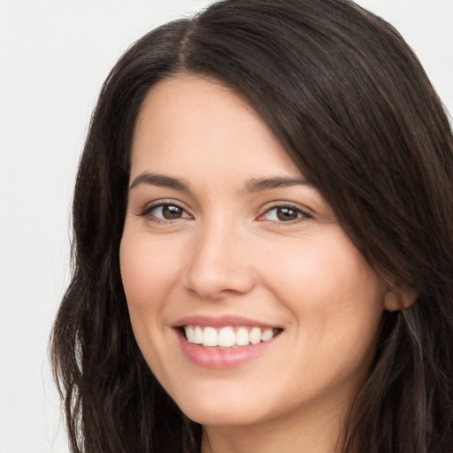 Joyful white young-adult female with long  brown hair and brown eyes