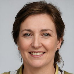 Joyful white adult female with medium  brown hair and grey eyes