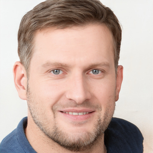 Joyful white young-adult male with short  brown hair and blue eyes