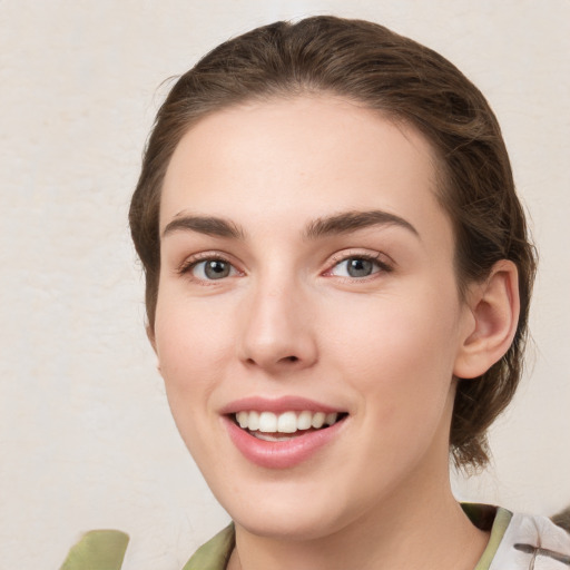 Joyful white young-adult female with medium  brown hair and green eyes