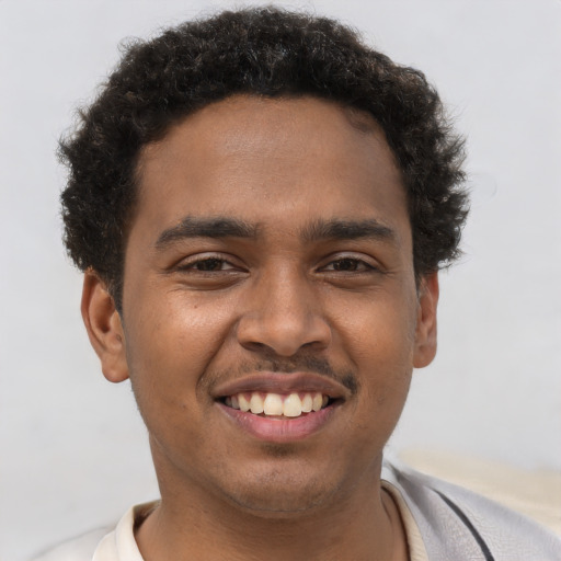 Joyful black young-adult male with short  brown hair and brown eyes