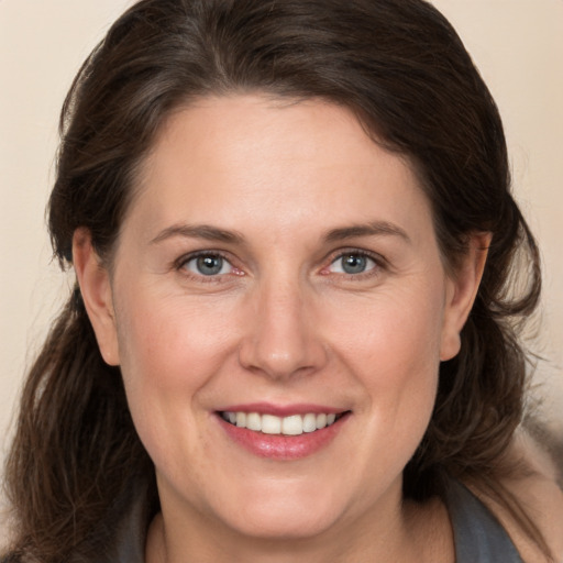 Joyful white adult female with medium  brown hair and grey eyes