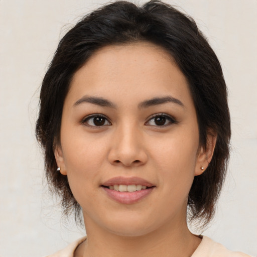 Joyful latino young-adult female with medium  brown hair and brown eyes