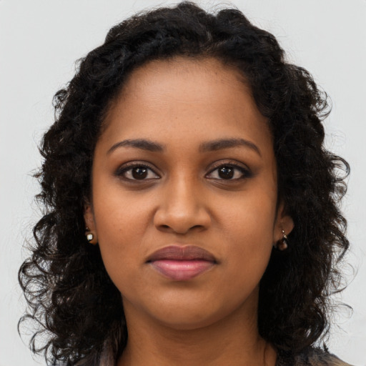 Joyful black young-adult female with long  brown hair and brown eyes