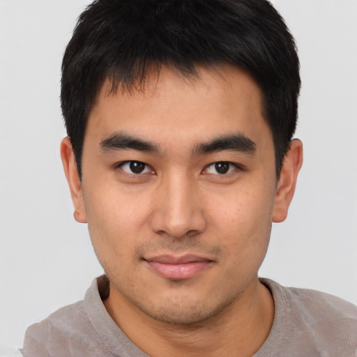 Joyful asian young-adult male with short  brown hair and brown eyes