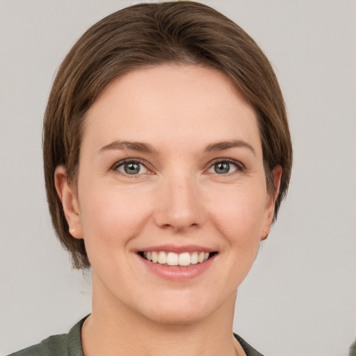 Joyful white young-adult female with short  brown hair and green eyes