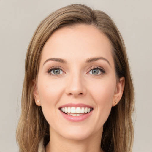 Joyful white young-adult female with long  brown hair and green eyes