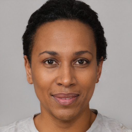 Joyful black adult female with short  black hair and brown eyes