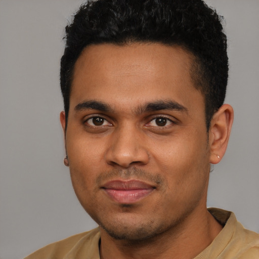 Joyful latino young-adult male with short  black hair and brown eyes