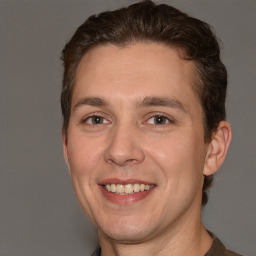 Joyful white adult male with short  brown hair and brown eyes