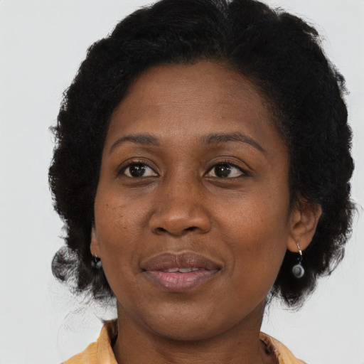Joyful black adult female with medium  brown hair and brown eyes