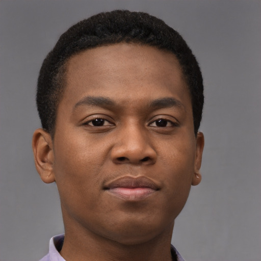 Joyful black young-adult male with short  brown hair and brown eyes