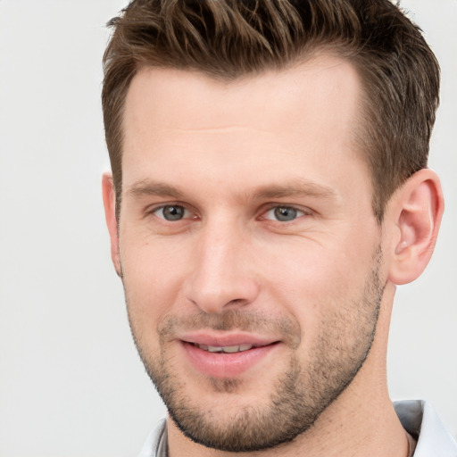 Joyful white young-adult male with short  brown hair and grey eyes