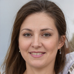 Joyful white adult female with long  brown hair and brown eyes