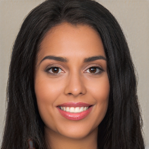 Joyful latino young-adult female with long  black hair and brown eyes