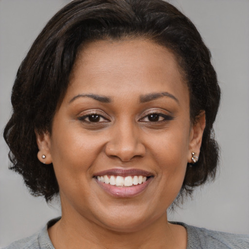 Joyful latino young-adult female with medium  brown hair and brown eyes