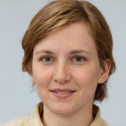 Joyful white adult female with medium  brown hair and grey eyes