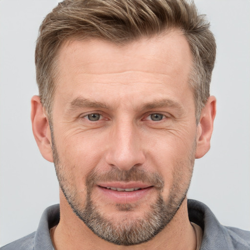 Joyful white adult male with short  brown hair and grey eyes