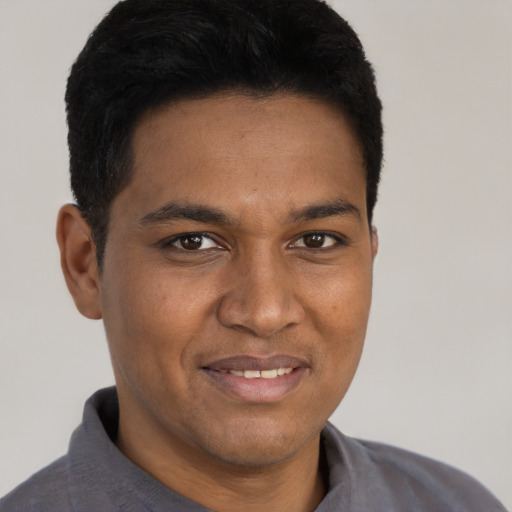 Joyful black young-adult male with short  brown hair and brown eyes