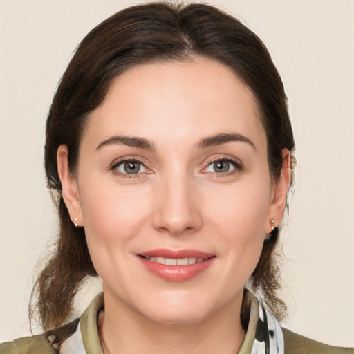 Joyful white young-adult female with medium  brown hair and grey eyes