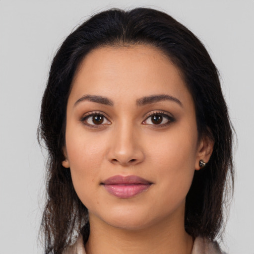 Joyful latino young-adult female with long  brown hair and brown eyes