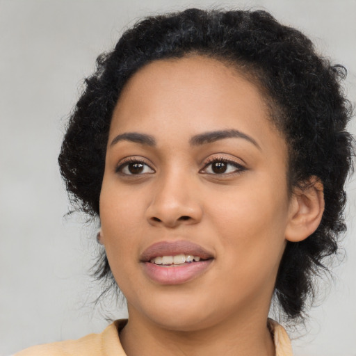 Joyful black young-adult female with long  black hair and brown eyes