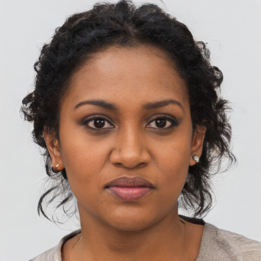 Joyful black young-adult female with medium  black hair and brown eyes