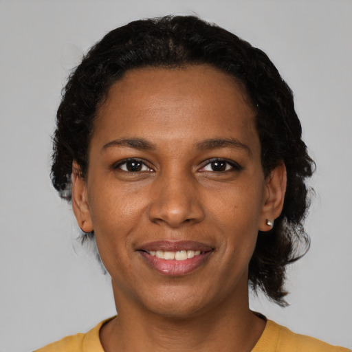Joyful black young-adult female with short  black hair and brown eyes