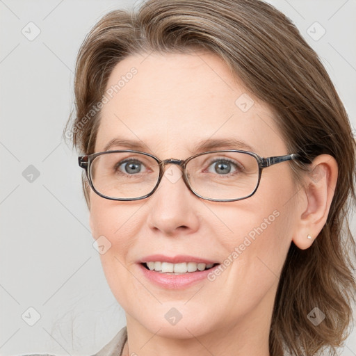 Joyful white adult female with medium  brown hair and blue eyes