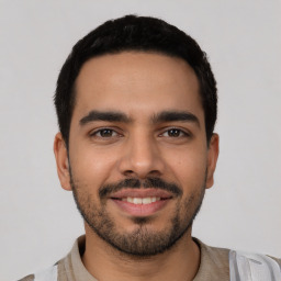 Joyful latino young-adult male with short  black hair and brown eyes