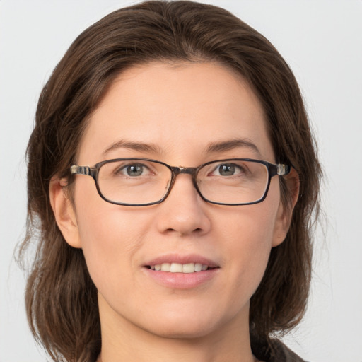 Joyful white young-adult female with medium  brown hair and grey eyes