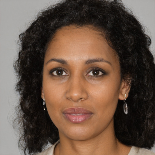 Joyful black young-adult female with medium  brown hair and brown eyes