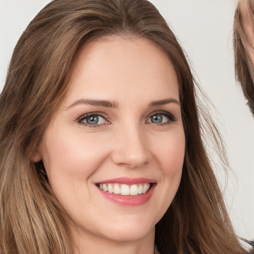 Joyful white young-adult female with long  brown hair and brown eyes