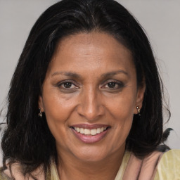 Joyful black adult female with medium  brown hair and brown eyes