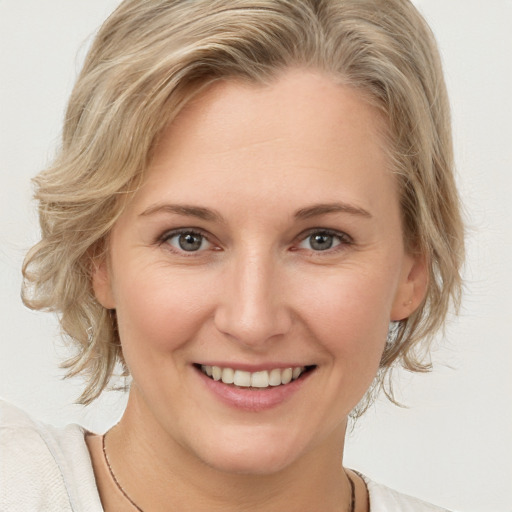 Joyful white young-adult female with medium  blond hair and brown eyes