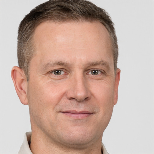 Joyful white adult male with short  brown hair and grey eyes