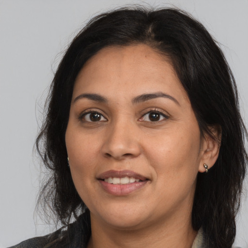 Joyful latino adult female with medium  brown hair and brown eyes