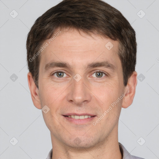 Joyful white young-adult male with short  brown hair and grey eyes