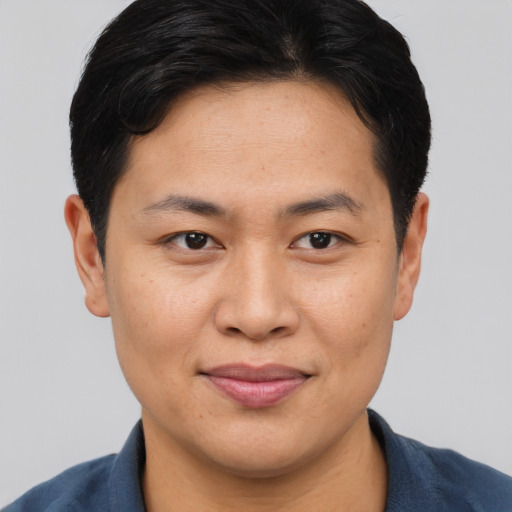 Joyful asian young-adult male with short  brown hair and brown eyes