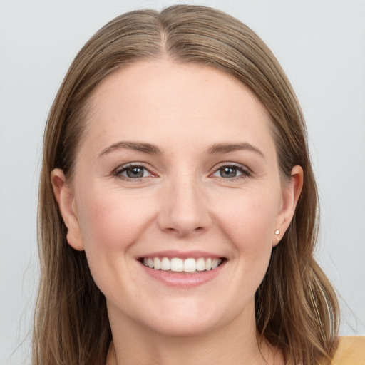 Joyful white young-adult female with long  brown hair and grey eyes